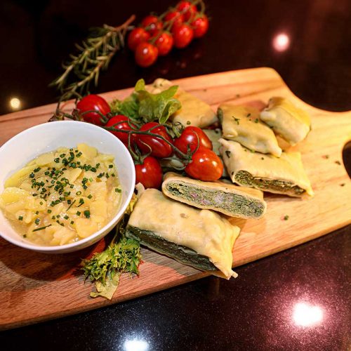 Maultaschen nebst Kartoffelsalat am Holzbrett